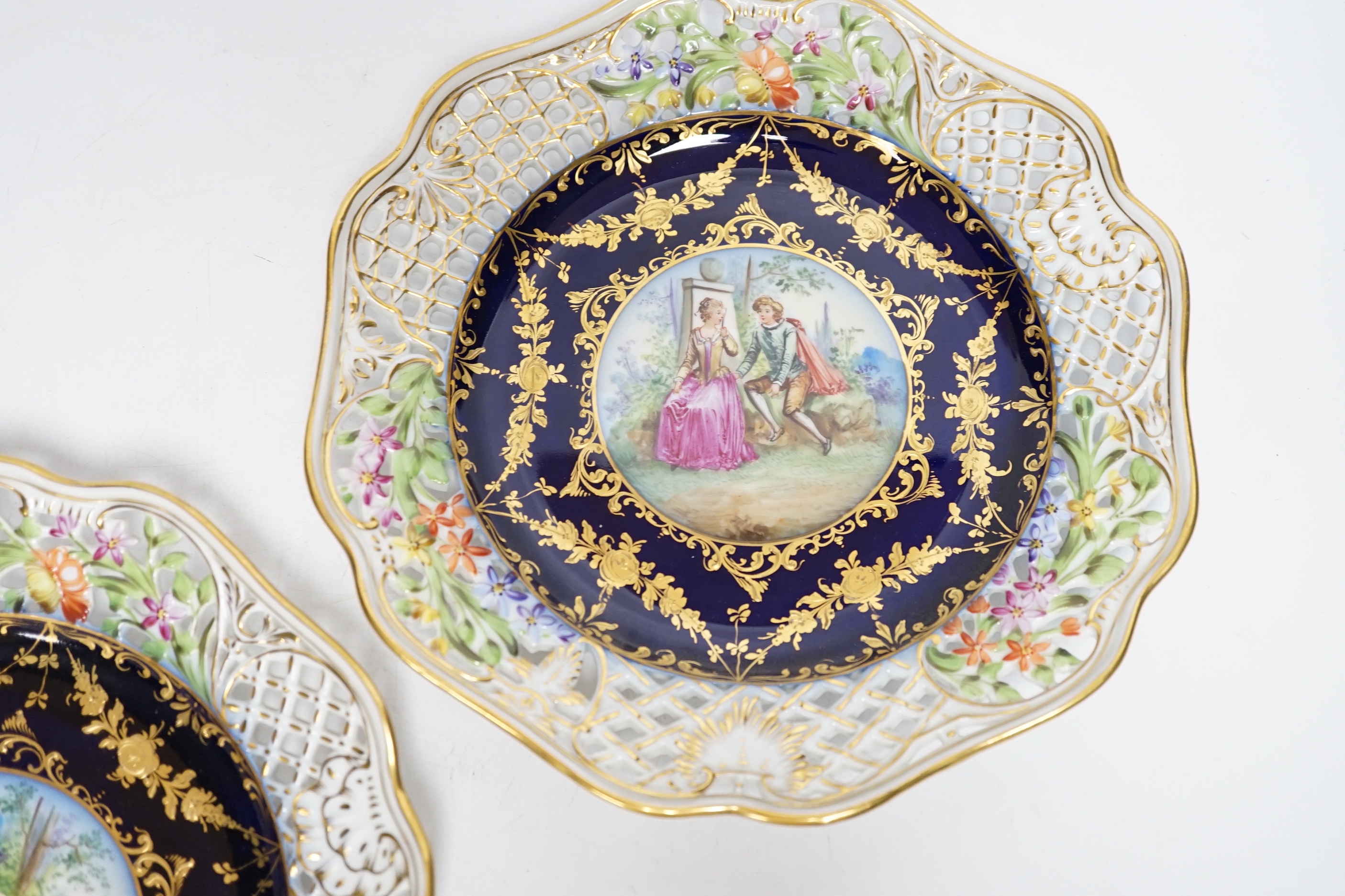 A pair of Dresden blue cabinet plates decorated with central cartouche of lovers, 22cm diameter